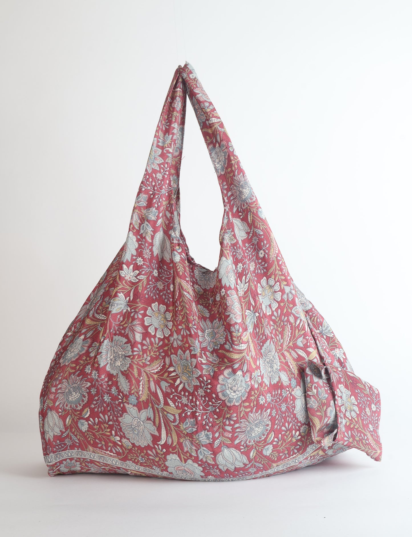 Stay eco-conscious with our Reusable Bag, handmade by Indian artisans from pre-loved saris. Silky and lightweight, this foldaway bag is perfect for your on-the-go lifestyle. Each piece is a unique statement of ethical fashion, embracing sustainability and style.