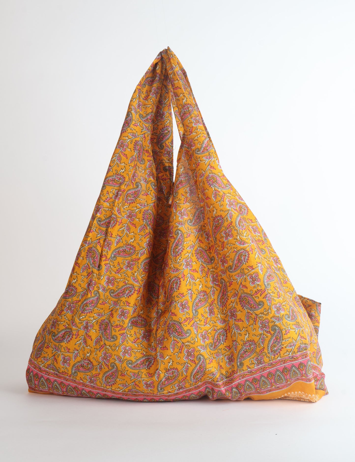 Stay eco-conscious with our Reusable Bag, handmade by Indian artisans from pre-loved saris. Silky and lightweight, this foldaway bag is perfect for your on-the-go lifestyle. Each piece is a unique statement of ethical fashion, embracing sustainability and style.