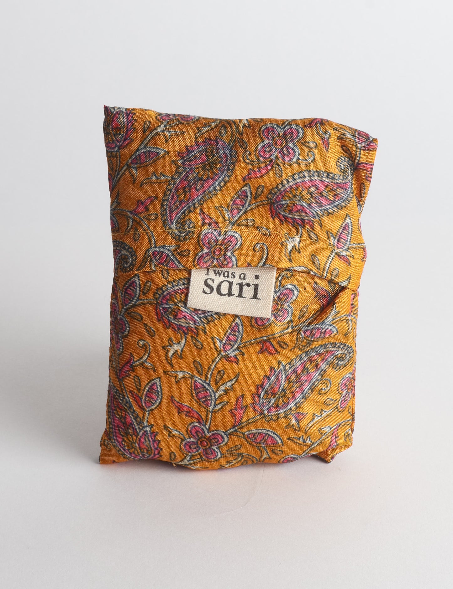Stay eco-conscious with our Reusable Bag, handmade by Indian artisans from pre-loved saris. Silky and lightweight, this foldaway bag is perfect for your on-the-go lifestyle. Each piece is a unique statement of ethical fashion, embracing sustainability and style.