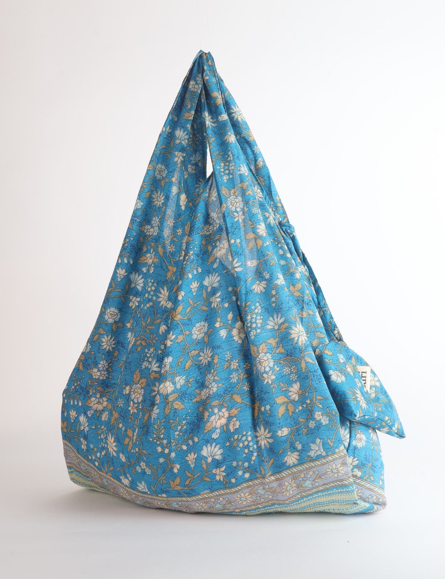 Stay eco-conscious with our Reusable Bag, handmade by Indian artisans from pre-loved saris. Silky and lightweight, this foldaway bag is perfect for your on-the-go lifestyle. Each piece is a unique statement of ethical fashion, embracing sustainability and style.