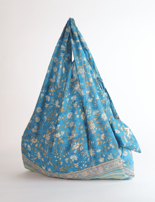 Stay eco-conscious with our Reusable Bag, handmade by Indian artisans from pre-loved saris. Silky and lightweight, this foldaway bag is perfect for your on-the-go lifestyle. Each piece is a unique statement of ethical fashion, embracing sustainability and style.