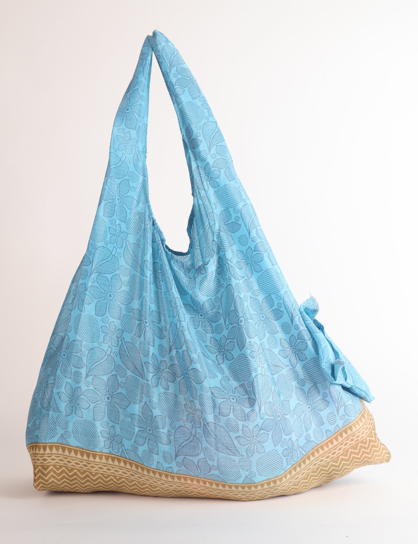Stay eco-conscious with our Reusable Bag, handmade by Indian artisans from pre-loved saris. Silky and lightweight, this foldaway bag is perfect for your on-the-go lifestyle. Each piece is a unique statement of ethical fashion, embracing sustainability and style.
