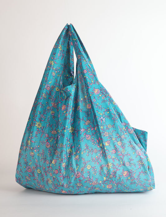 Stay eco-conscious with our Reusable Bag, handmade by Indian artisans from pre-loved saris. Silky and lightweight, this foldaway bag is perfect for your on-the-go lifestyle. Each piece is a unique statement of ethical fashion, embracing sustainability and style.