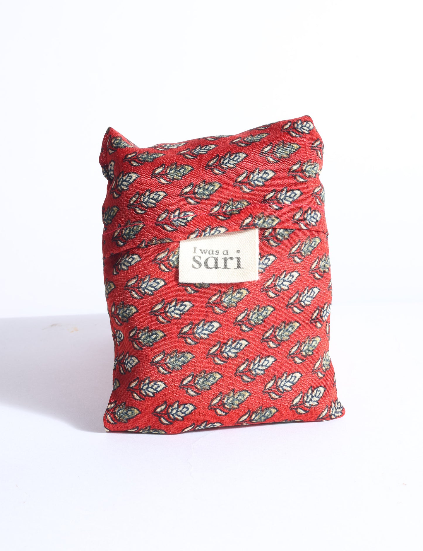 Blue reusable bag with multicolor tropical floral pattern folded with "I was a sari" label visible on front