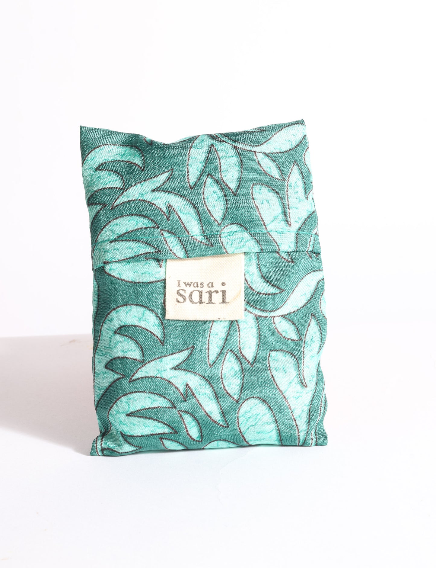Blue reusable bag with multicolor tropical floral pattern folded with "I was a sari" label visible on front