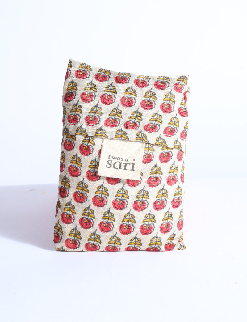 Blue reusable bag with multicolor tropical floral pattern folded with "I was a sari" label visible on front
