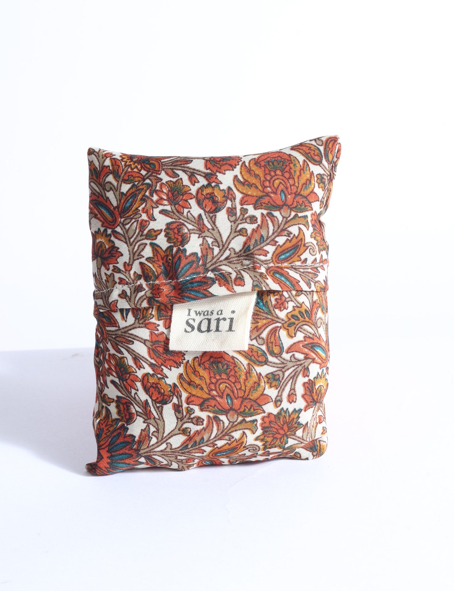 Blue reusable bag with multicolor tropical floral pattern folded with "I was a sari" label visible on front