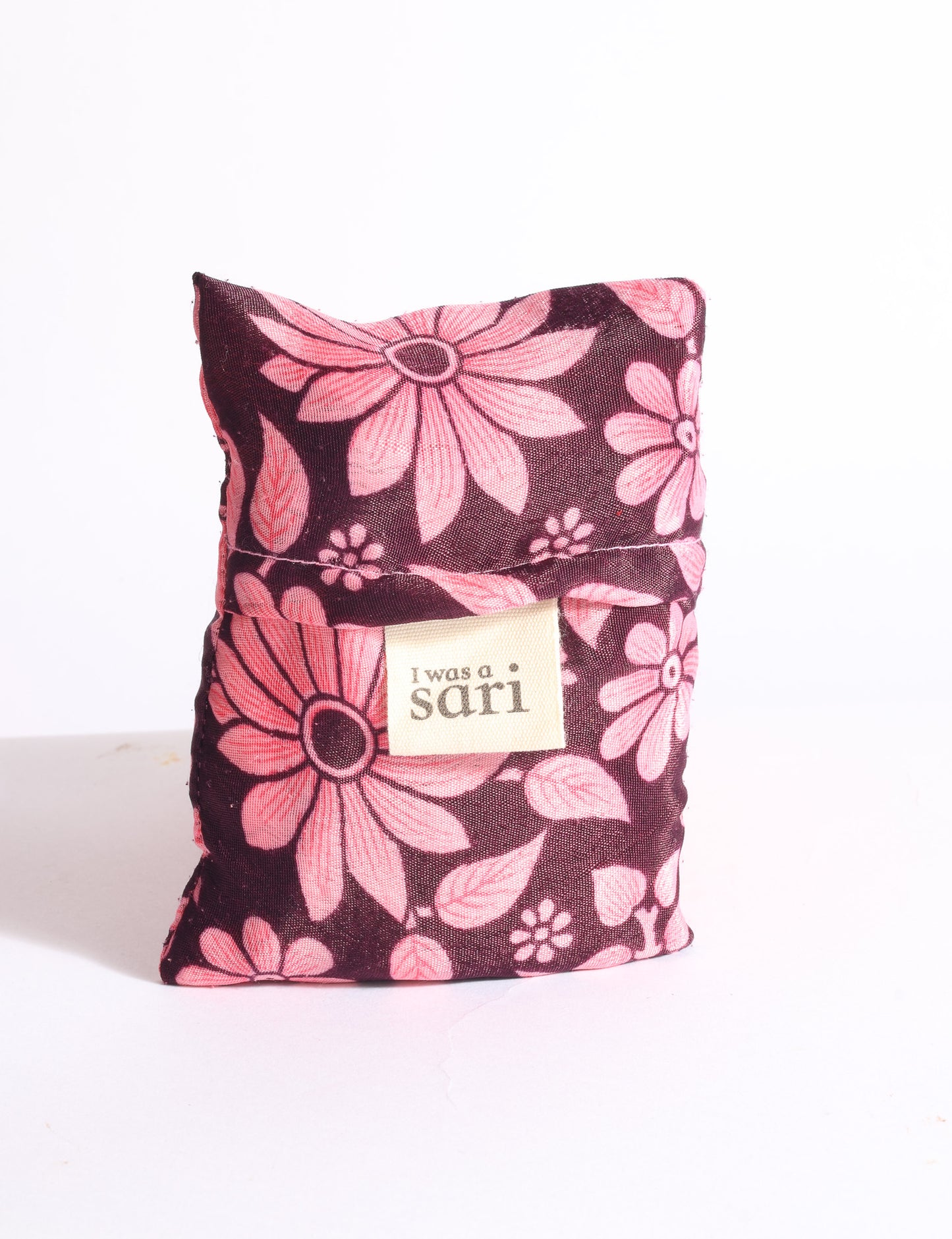 Blue reusable bag with multicolor tropical floral pattern folded with "I was a sari" label visible on front