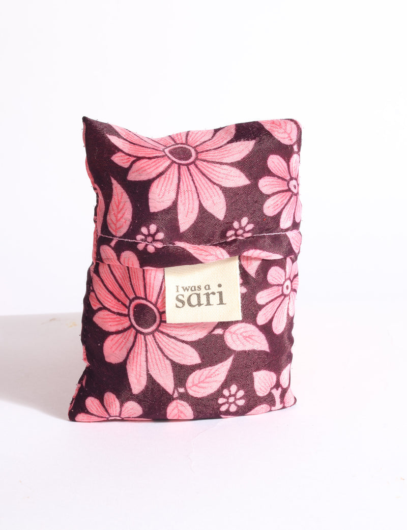 Blue reusable bag with multicolor tropical floral pattern folded with "I was a sari" label visible on front