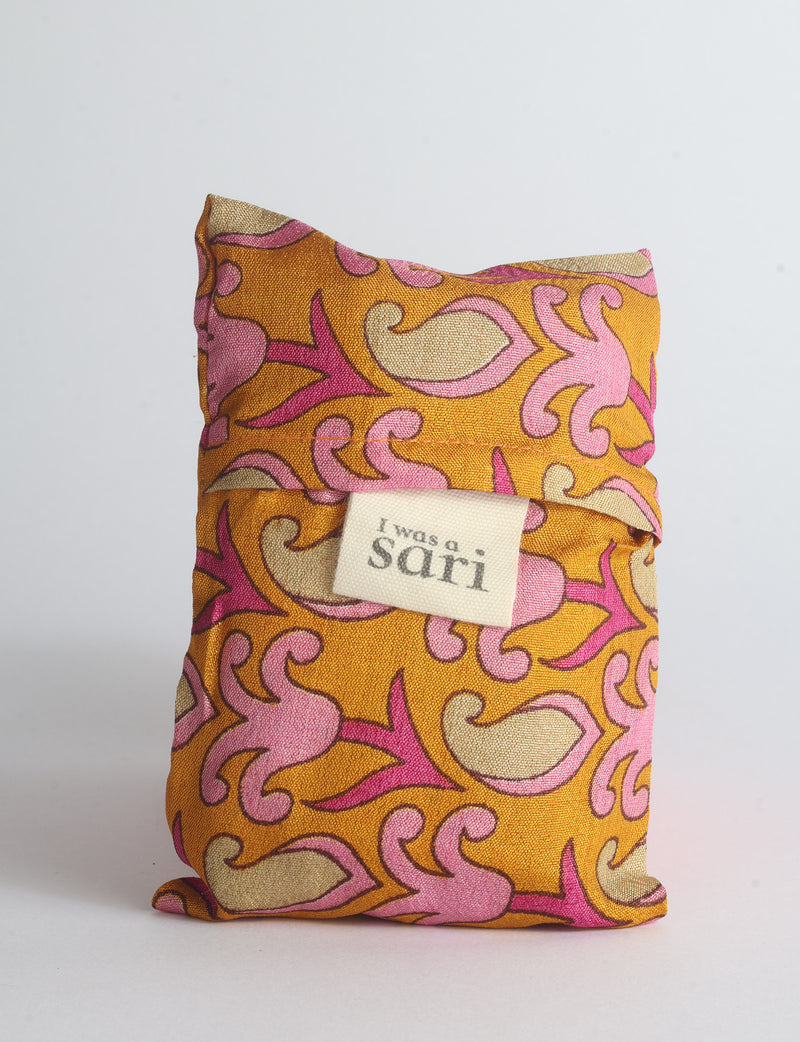 Blue reusable bag with multicolor tropical floral pattern folded with "I was a sari" label visible on front