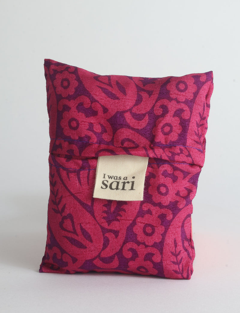 Blue reusable bag with multicolor tropical floral pattern folded with "I was a sari" label visible on front