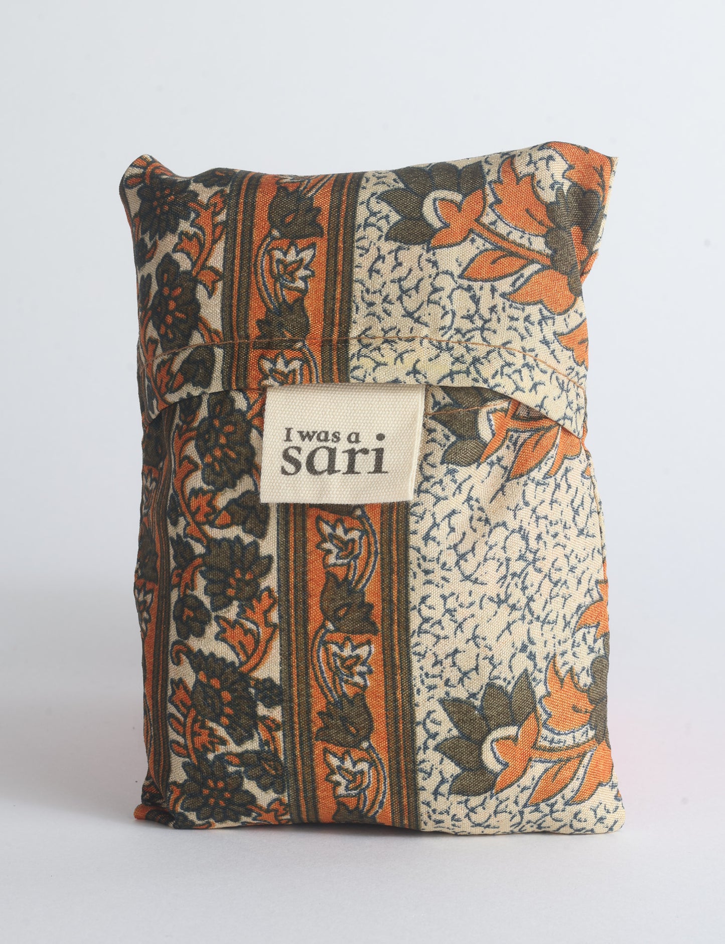 Blue reusable bag with multicolor tropical floral pattern folded with "I was a sari" label visible on front