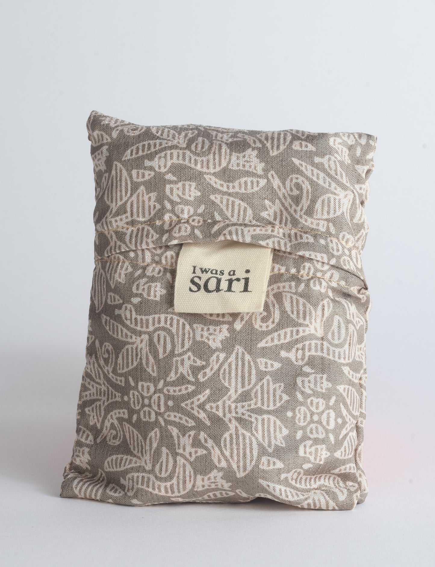 Blue reusable bag with multicolor tropical floral pattern folded with "I was a sari" label visible on front