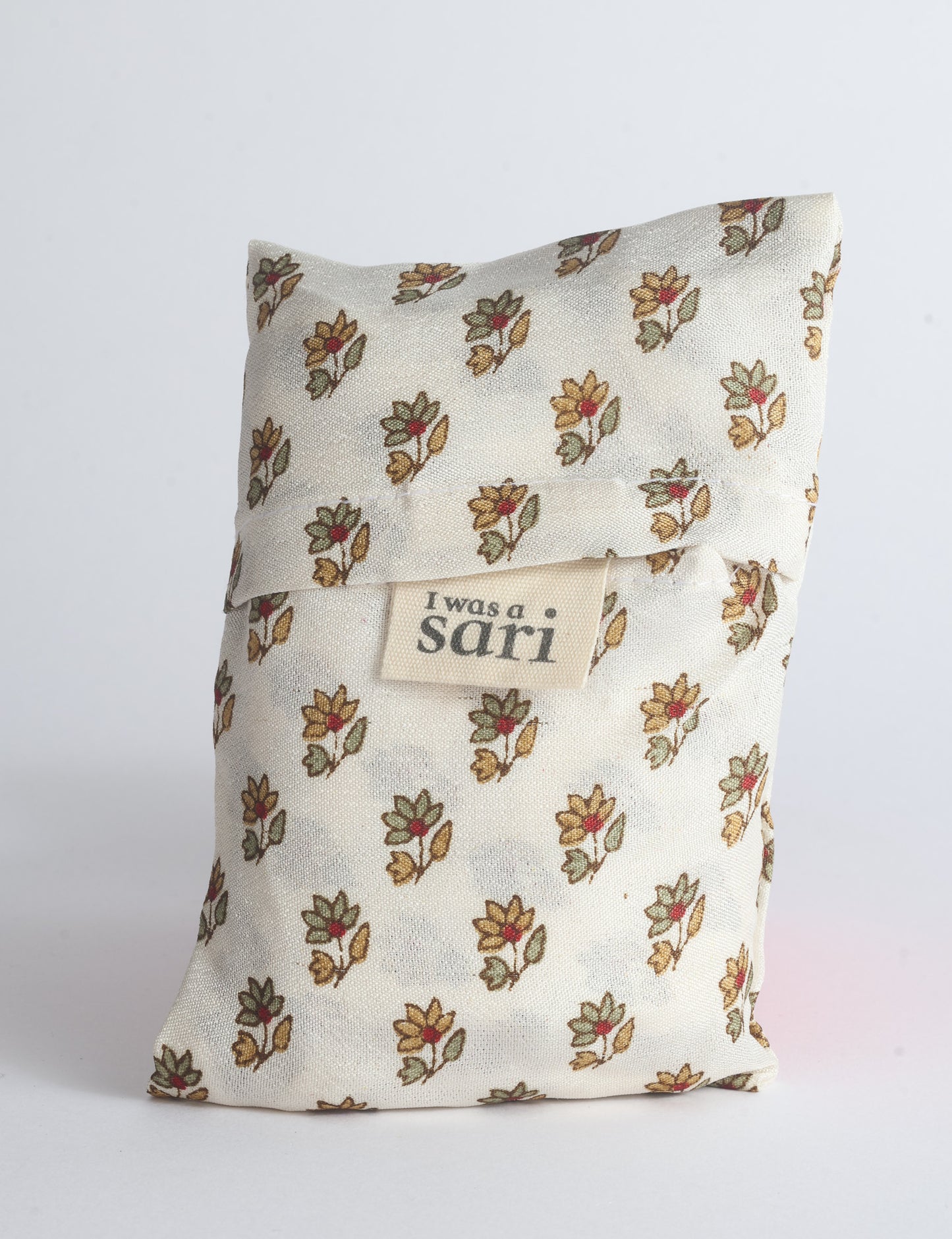Blue reusable bag with multicolor tropical floral pattern folded with "I was a sari" label visible on front