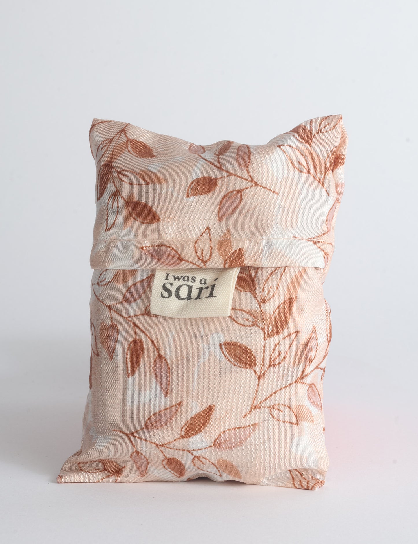 Blue reusable bag with multicolor tropical floral pattern folded with "I was a sari" label visible on front