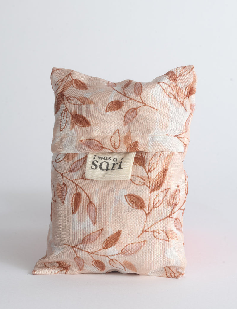 Blue reusable bag with multicolor tropical floral pattern folded with "I was a sari" label visible on front