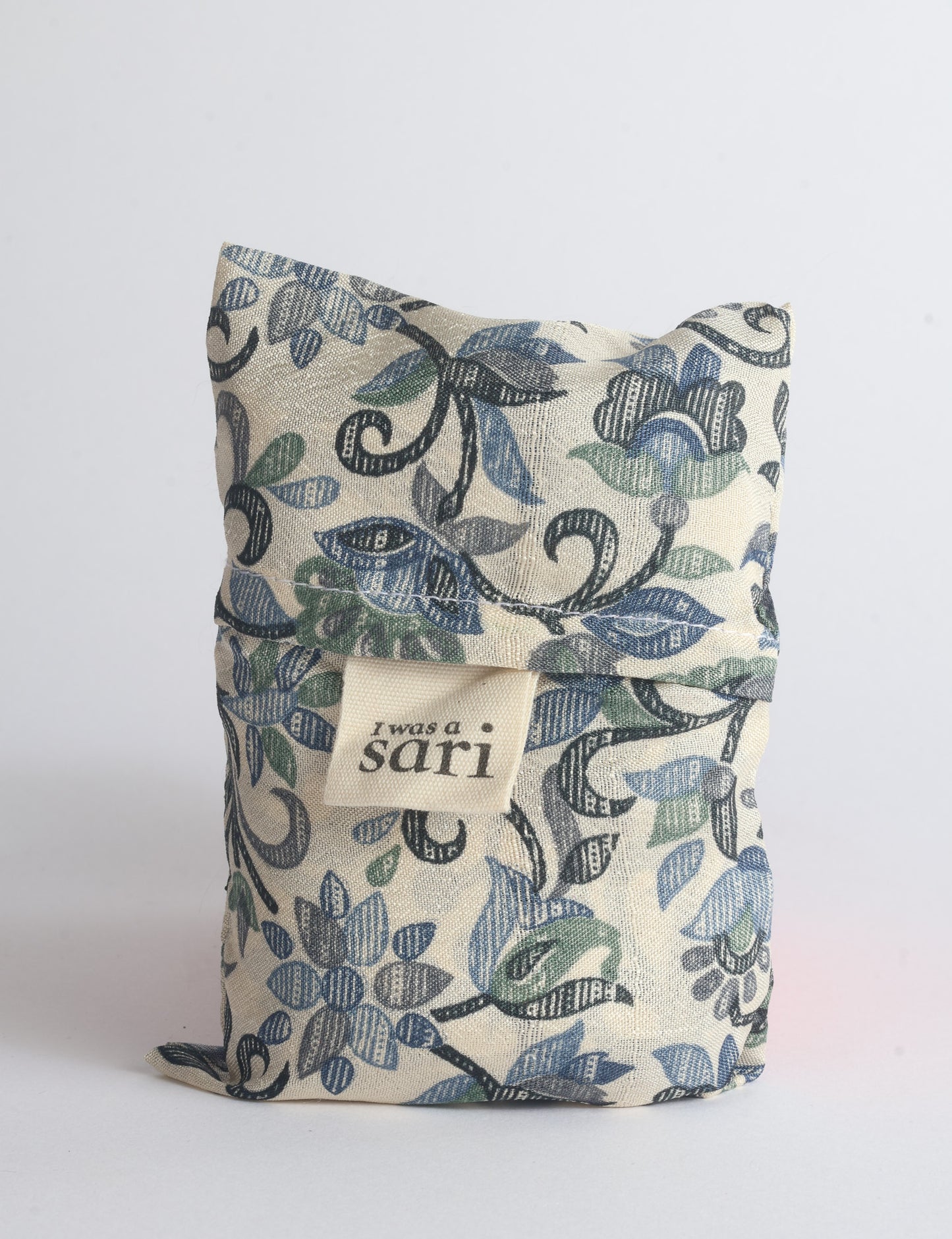 Blue reusable bag with multicolor tropical floral pattern folded with "I was a sari" label visible on front