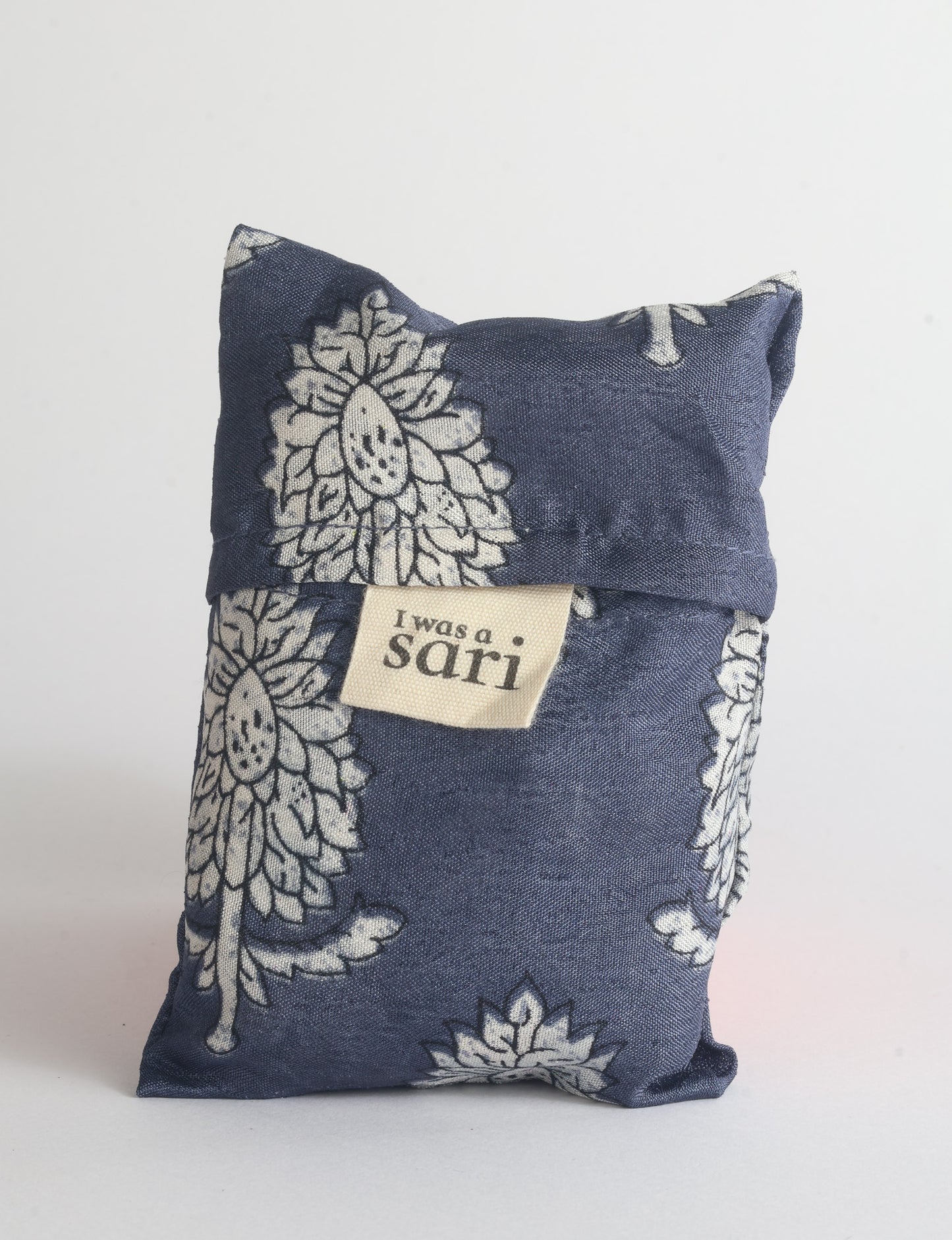 Blue reusable bag with multicolor tropical floral pattern folded with "I was a sari" label visible on front