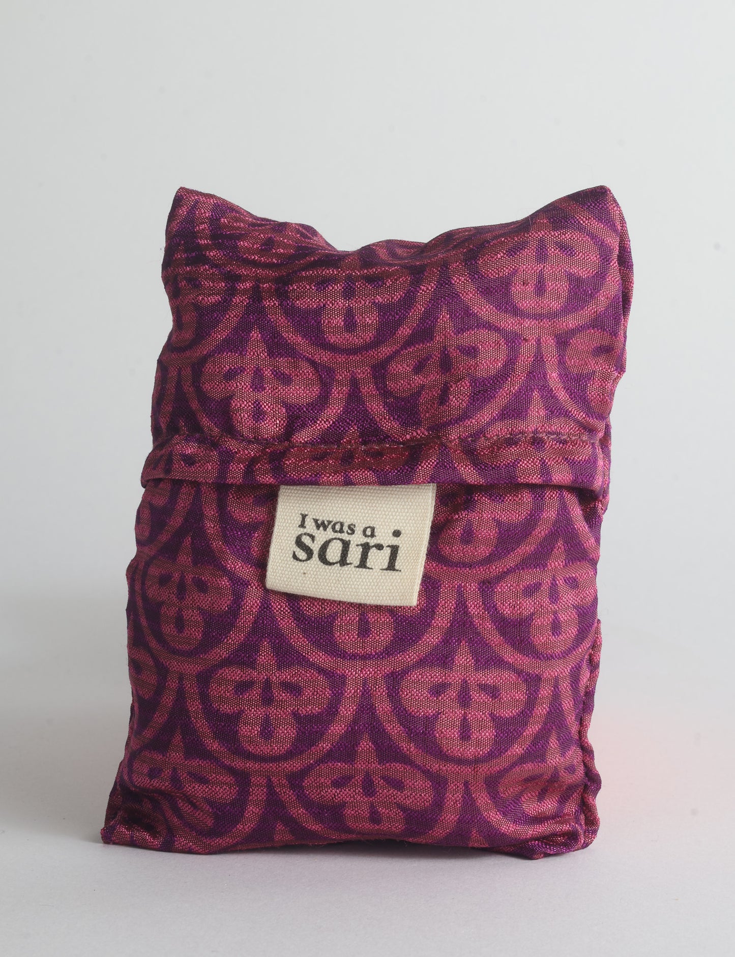 Blue reusable bag with multicolor tropical floral pattern folded with "I was a sari" label visible on front