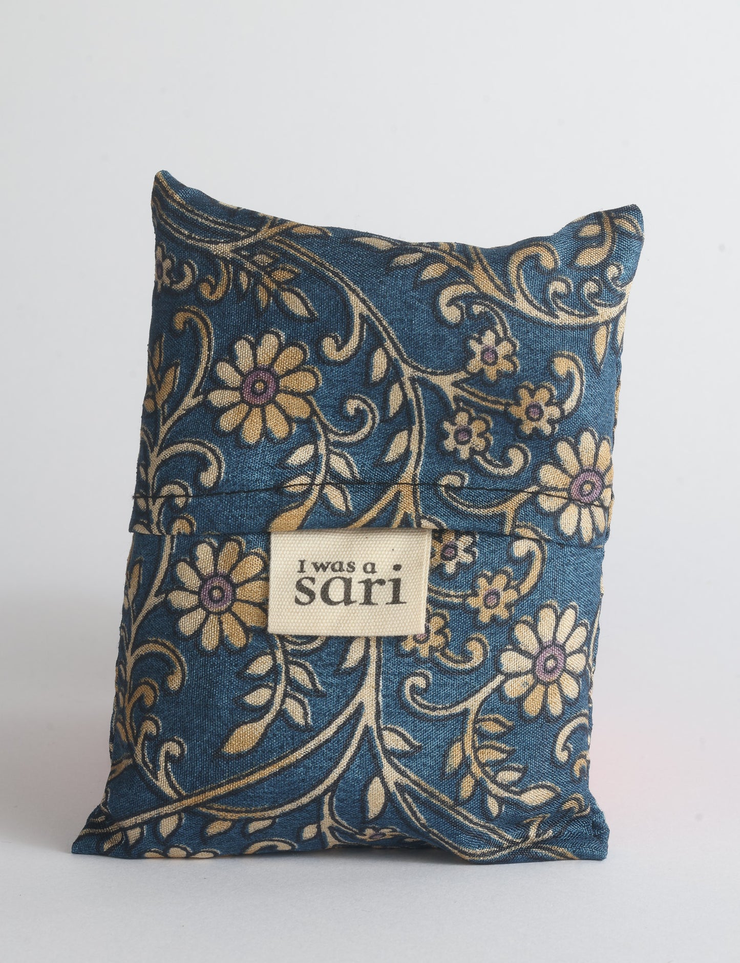 Blue reusable bag with multicolor tropical floral pattern folded with "I was a sari" label visible on front