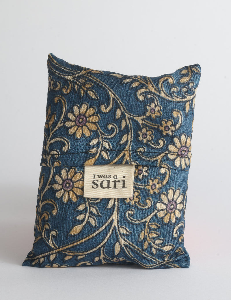Blue reusable bag with multicolor tropical floral pattern folded with "I was a sari" label visible on front