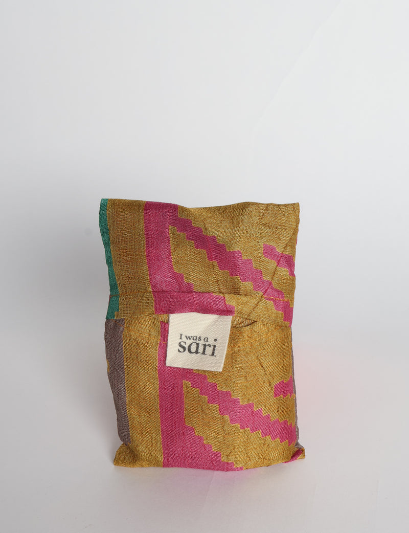 Blue reusable bag with multicolor tropical floral pattern folded with "I was a sari" label visible on front