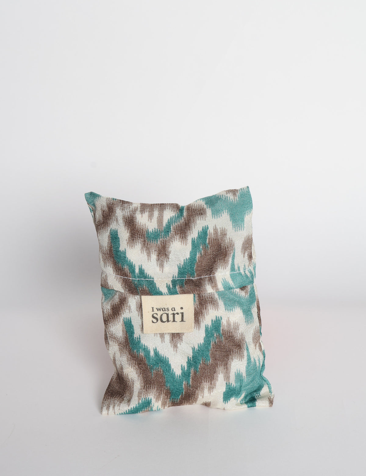 Blue reusable bag with multicolor tropical floral pattern folded with "I was a sari" label visible on front
