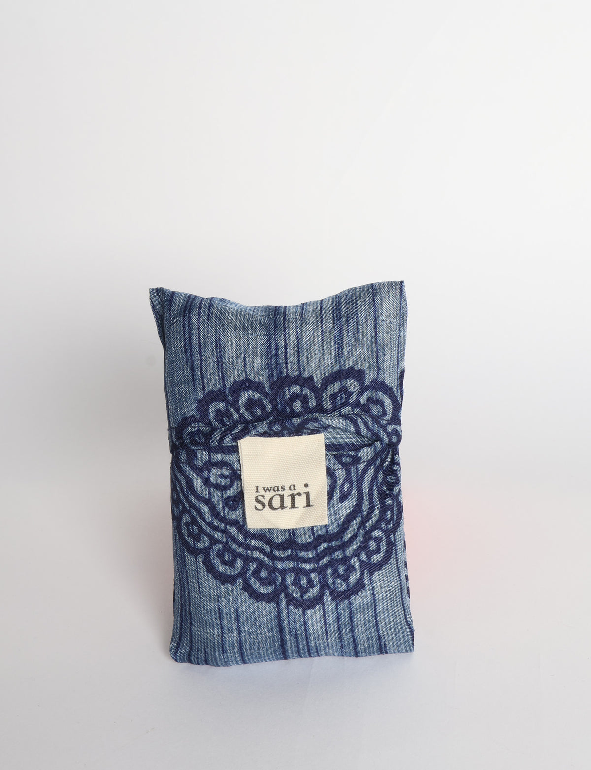 Blue reusable bag with multicolor tropical floral pattern folded with "I was a sari" label visible on front
