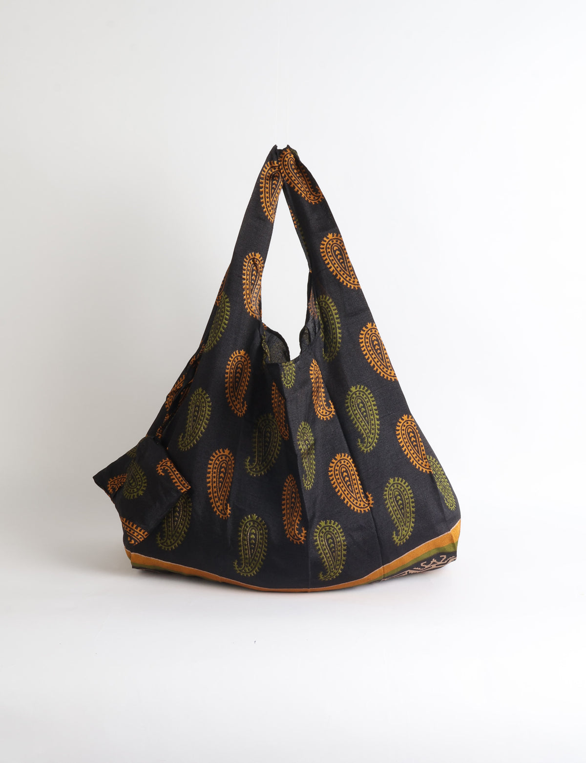 Blue reusable bag with tropical floral pattern in pink, yellow, and green, shown hanging with handles visible