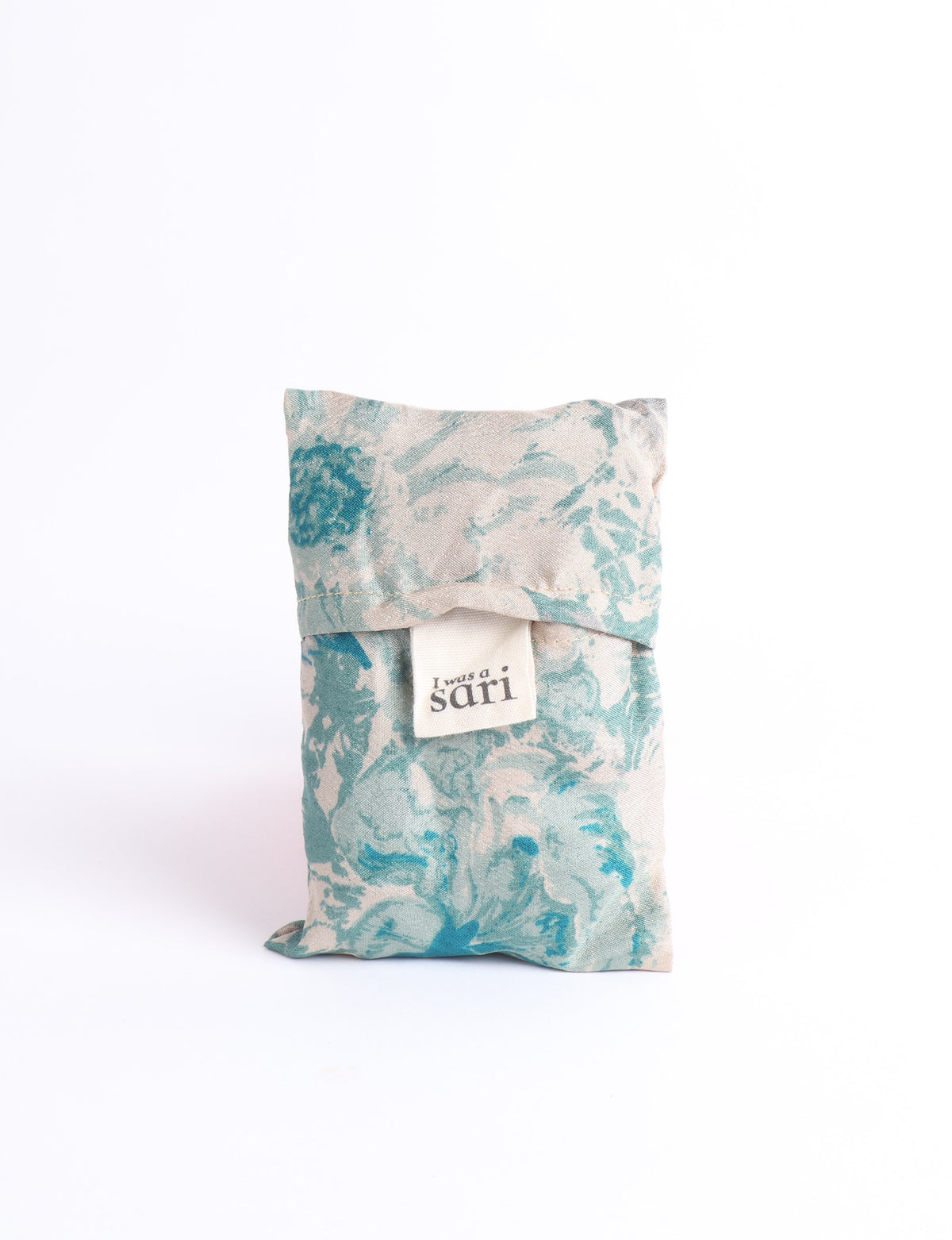 Blue reusable bag with multicolor tropical floral pattern folded with "I was a sari" label visible on front