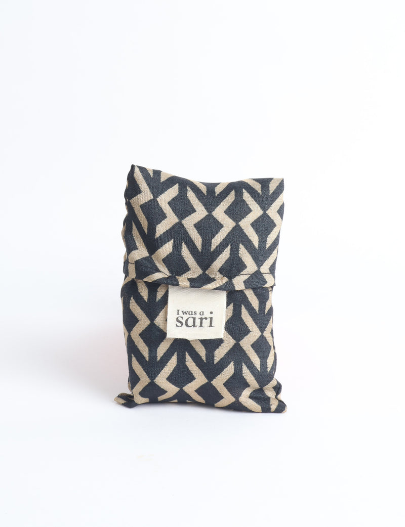 Blue reusable bag with multicolor tropical floral pattern folded with "I was a sari" label visible on front