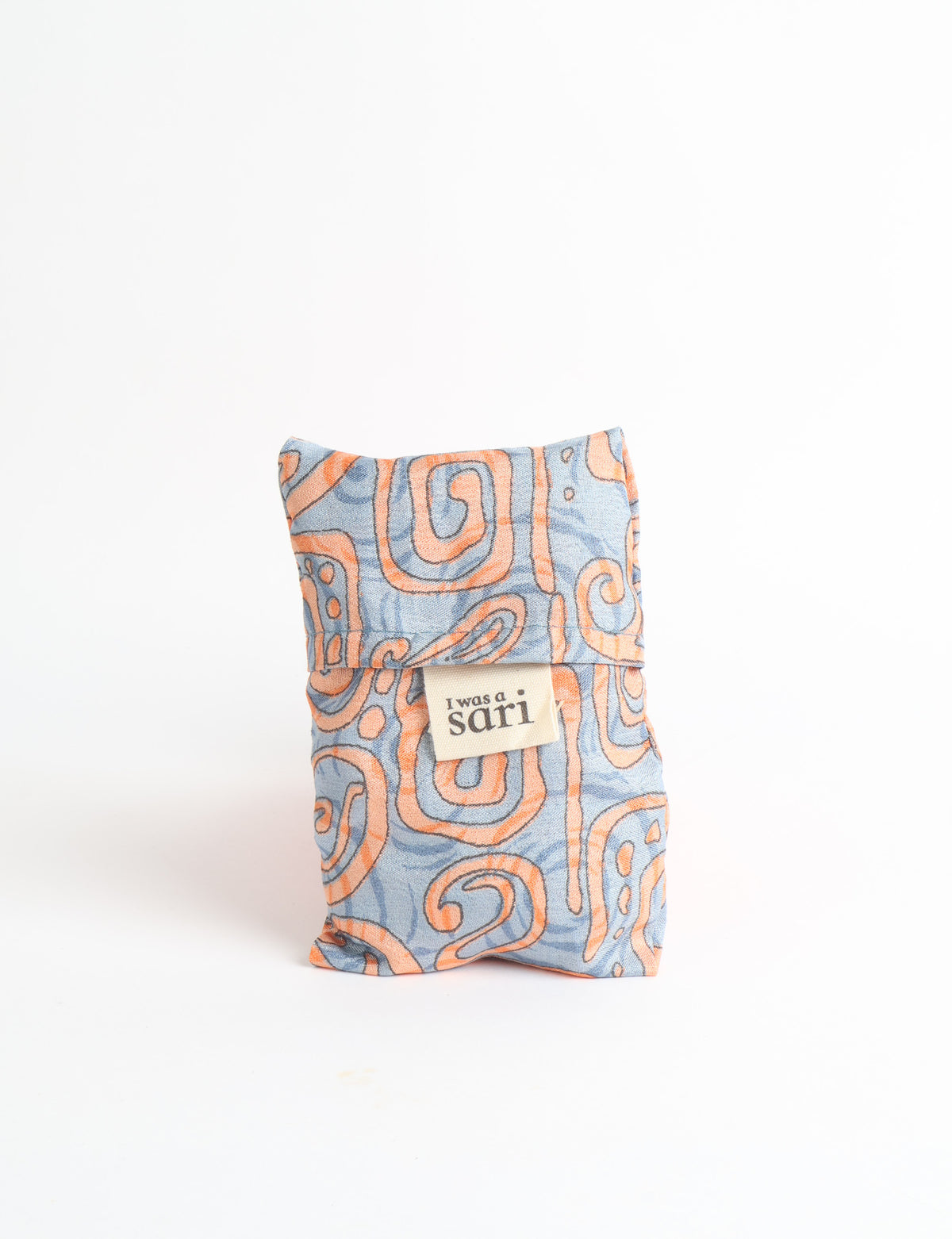 Blue reusable bag with multicolor tropical floral pattern folded with "I was a sari" label visible on front