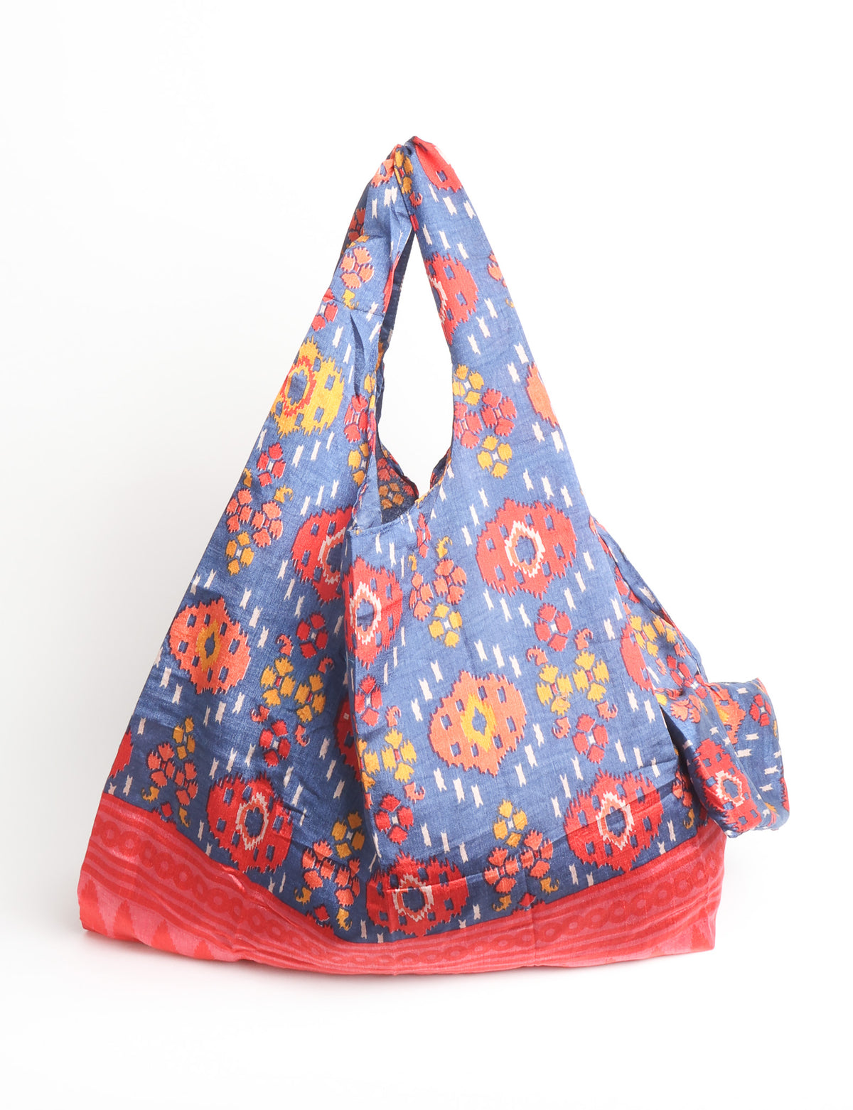 Blue reusable bag with multicolor tropical floral pattern folded with "I was a sari" label visible on front
