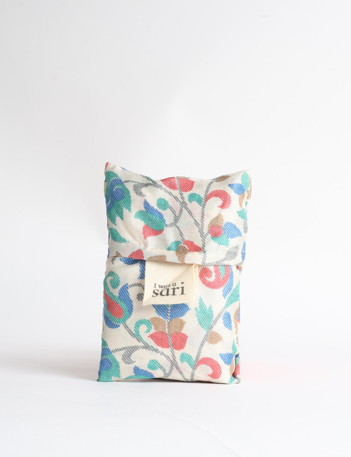 Blue reusable bag with tropical floral pattern in pink, yellow, and green, shown hanging with handles visible