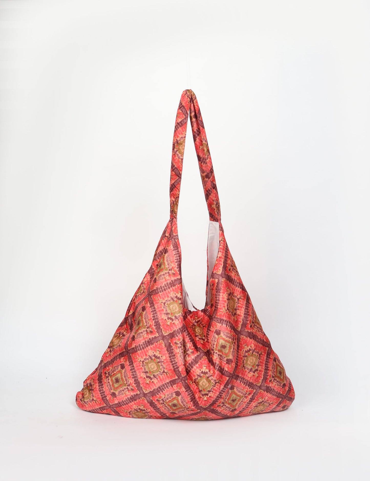 Trapeze bag made from repurposed sari fabric, featuring bold patterns and eco friendly cloth design—part of a sustainable women's clothing collection.