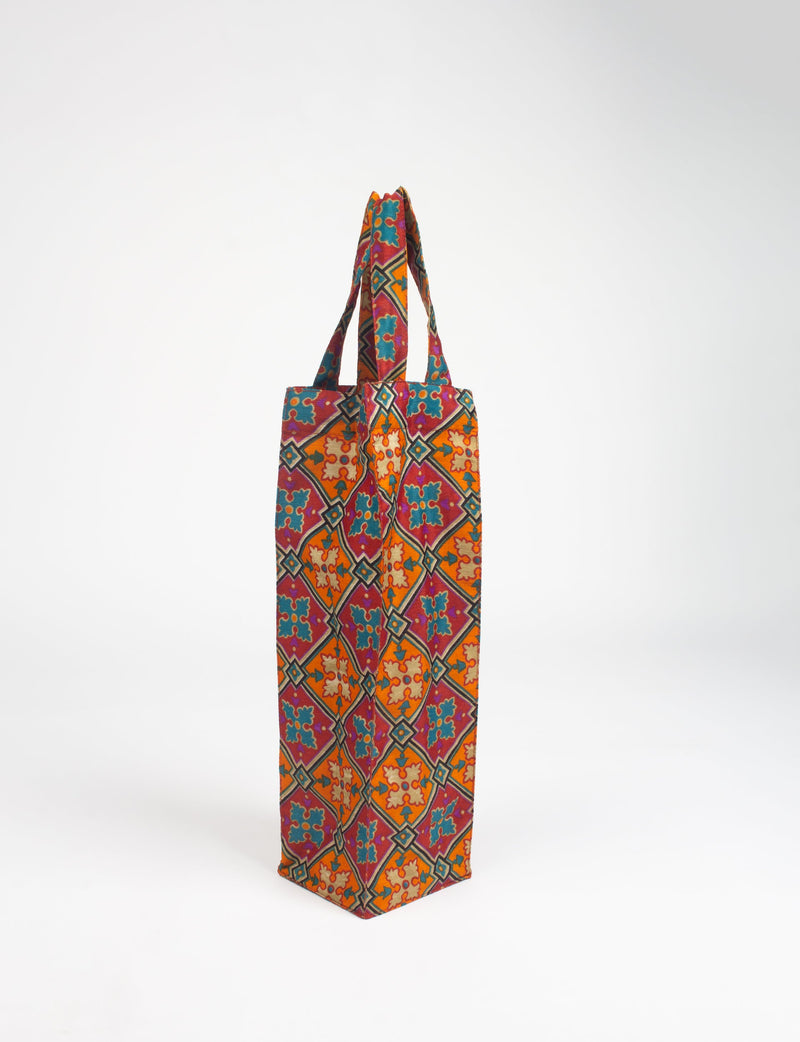 Orange wine bag with Indian ethnic floral and geometric pattern, fabric handles, standing upright on white background