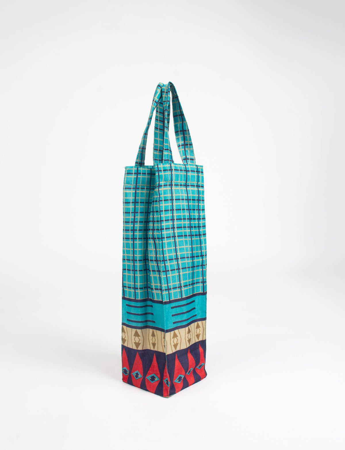 Blue geometric patterned fabric wine bag with handles, featuring red, beige, and navy decorative border at the bottom