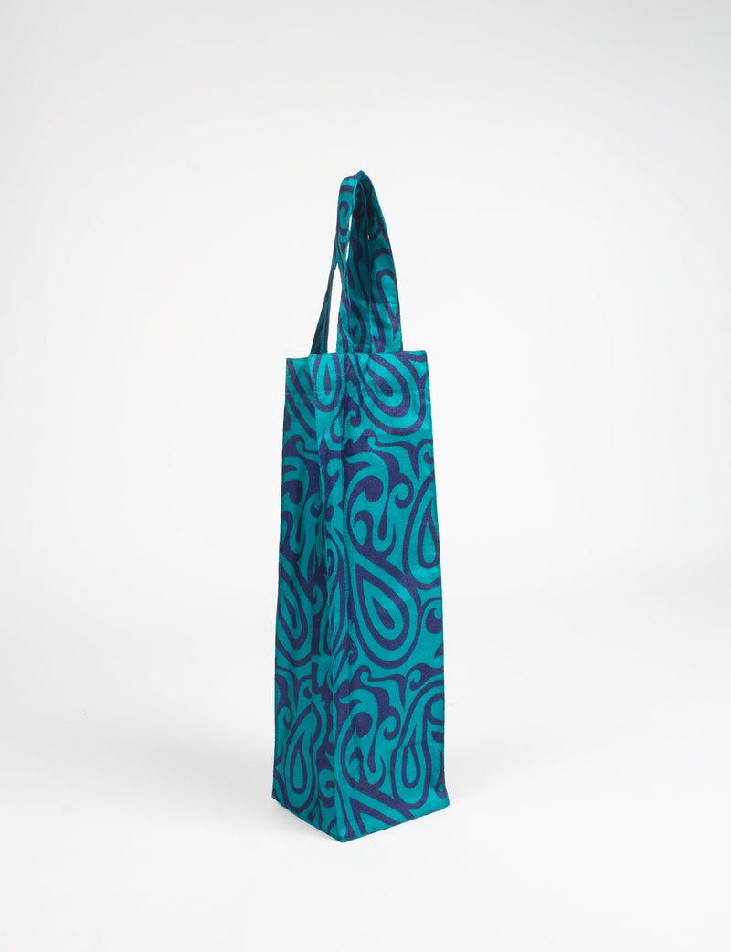 Blue fabric wine bag with dark blue paisley pattern and a single handle, shown standing upright on white background