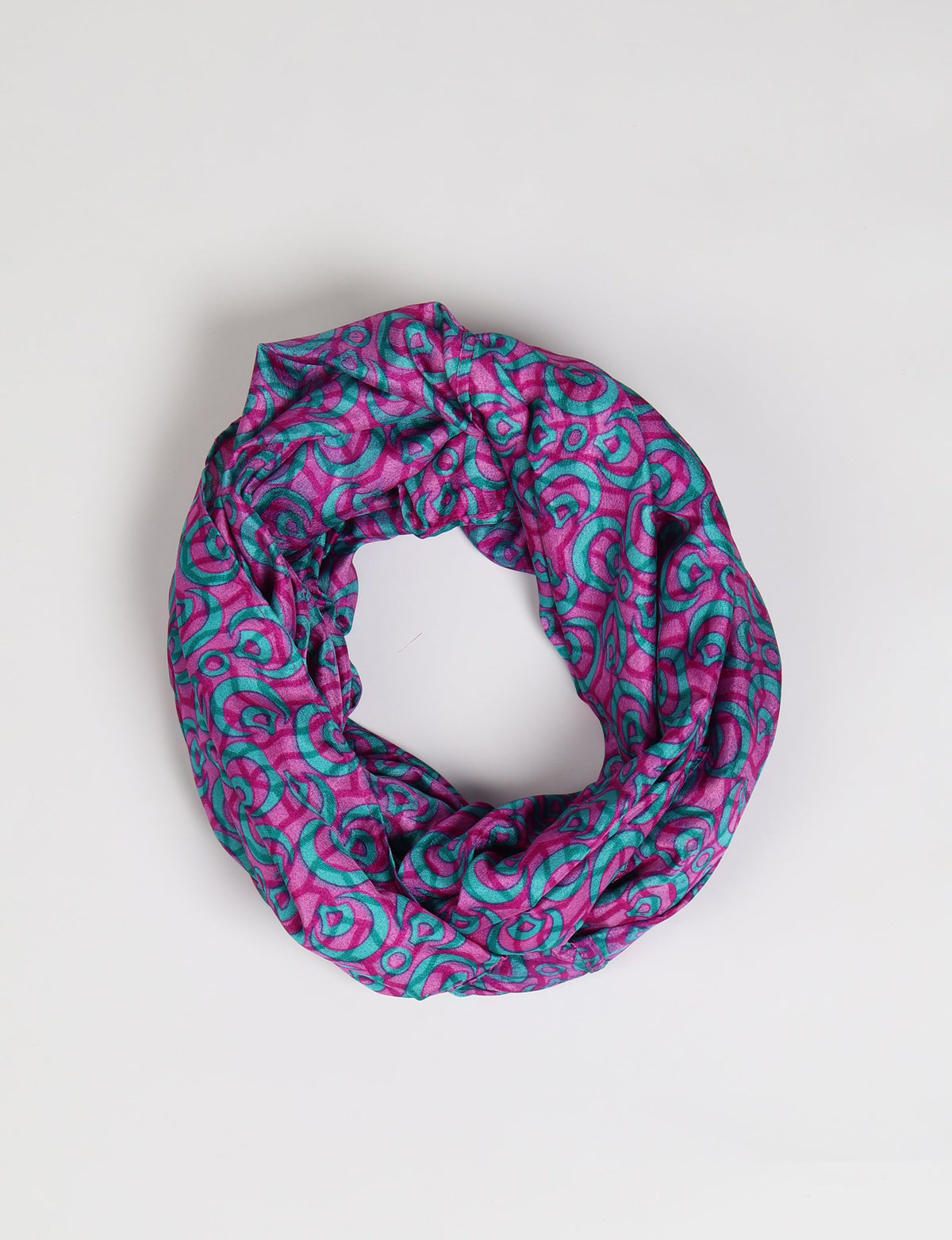 Pink and teal abstract patterned loop scarf shown flat on a white background