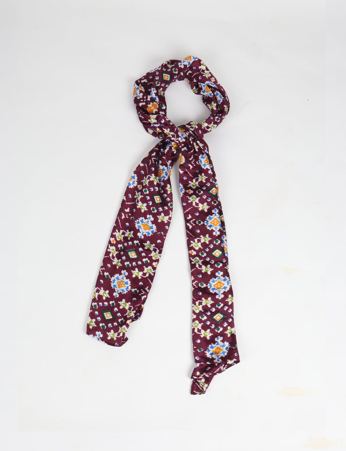 Purple stole with multicolor ethnic floral and geometric print, shown knotted on a white background