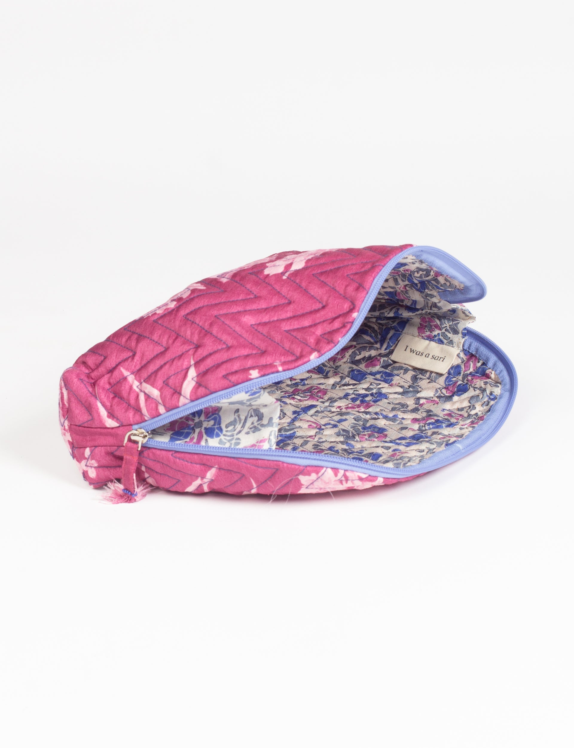 Pink tropical quilted vanity pouch with blue zipper and floral fabric interior labeled "I was a sari" shown open side view