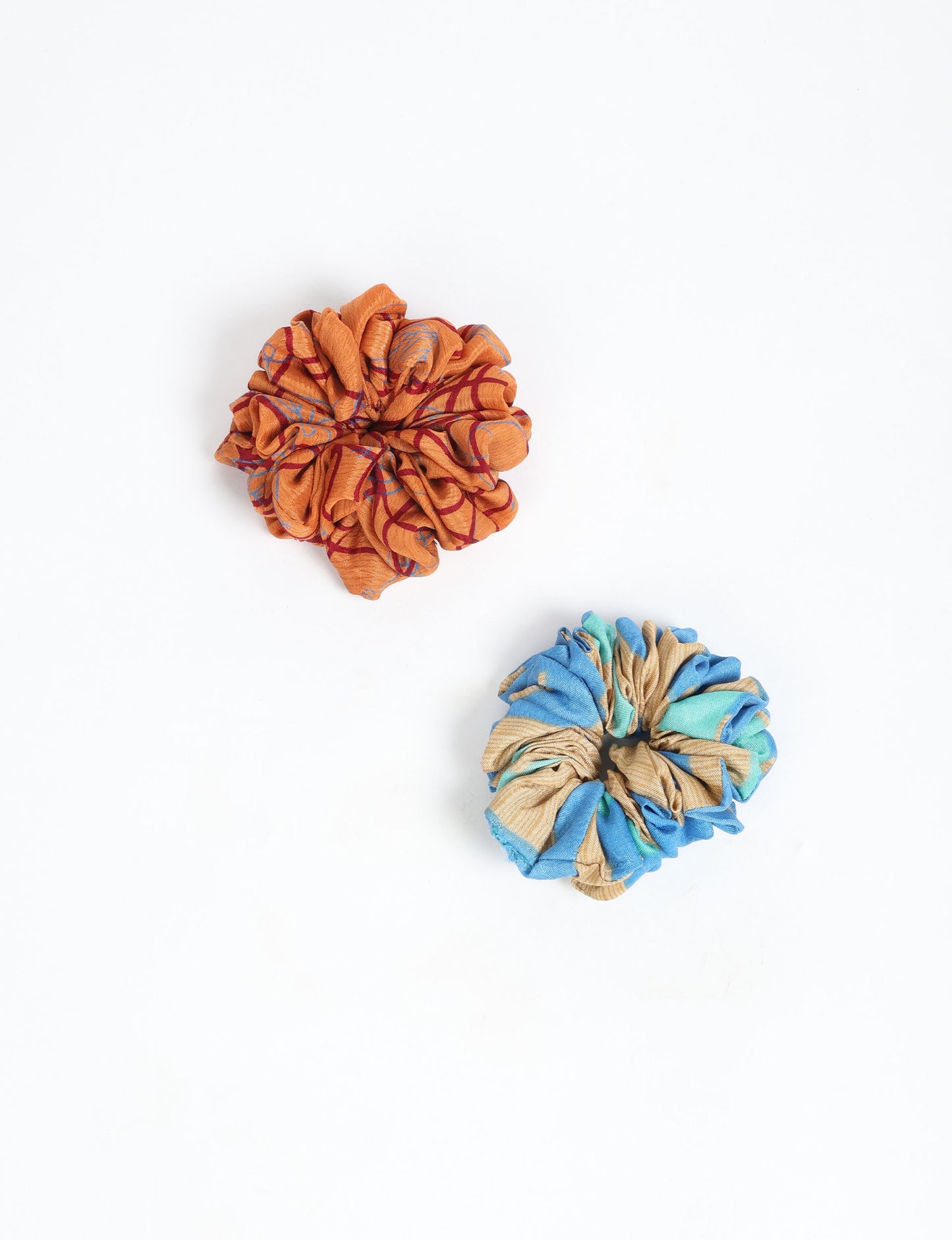 Upgrade your hairstyle with our Scrunchy Set of 2 – elastic hair ties wrapped in colorful Indian sari fabric. A top pick in ethical and green fashion, these eco-friendly prints add flair to your wrist and hair, making a sustainable style statement that catches attention and sparks change.