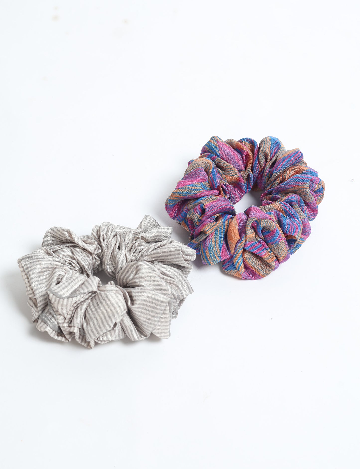 Upgrade your hairstyle with our Scrunchy Set of 2 – elastic hair ties wrapped in colorful Indian sari fabric. A top pick in ethical and green fashion, these eco-friendly prints add flair to your wrist and hair, making a sustainable style statement that catches attention and sparks change.