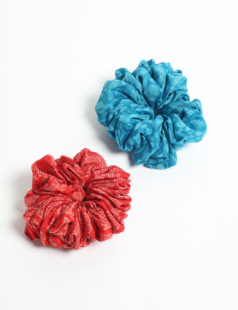Set of two scrunchies, one red with white text pattern and one solid blue, shown flat on white background