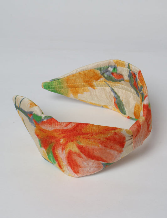 Upcycled sari hairband with central knot, handmade in India — an eco friendly fashion accessory representing green fashion, upcycled women’s clothing, fair trade fashion, and earth friendly clothing made from recycled sari textiles.