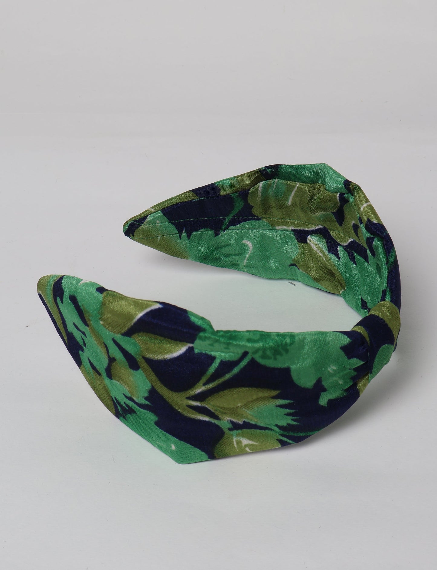 Upcycled sari hairband with central knot, handmade in India — an eco friendly fashion accessory representing green fashion, upcycled women’s clothing, fair trade fashion, and earth friendly clothing made from recycled sari textiles.