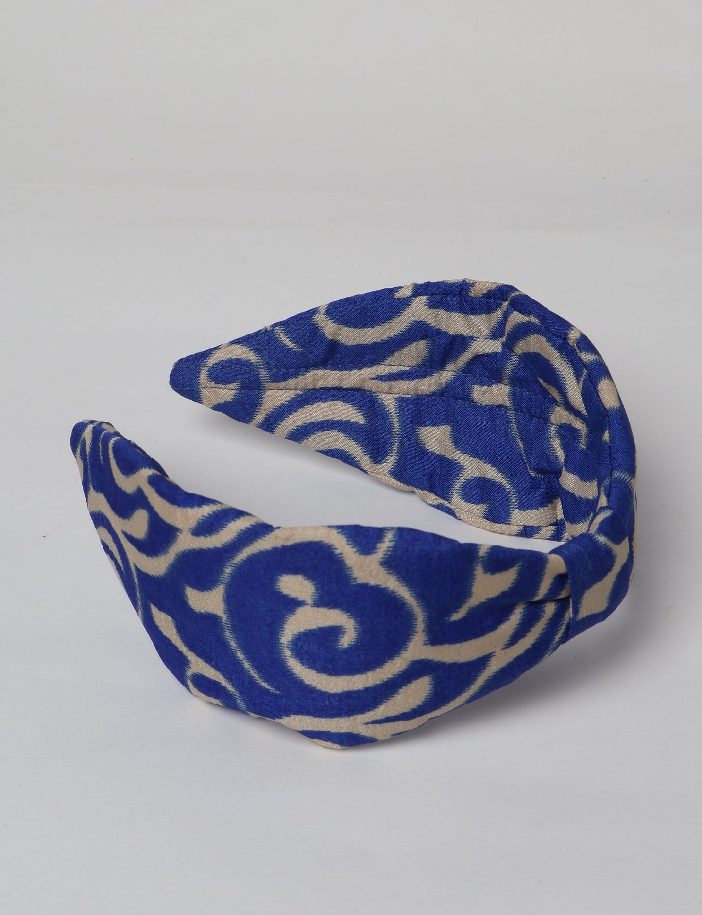 Upcycled sari hairband with central knot, handmade in India — an eco friendly fashion accessory representing green fashion, upcycled women’s clothing, fair trade fashion, and earth friendly clothing made from recycled sari textiles.