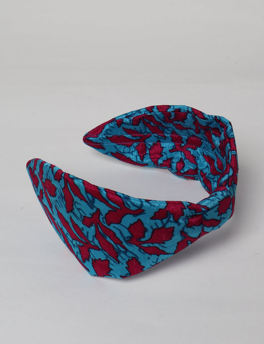 Upcycled sari hairband with central knot, handmade in India — an eco friendly fashion accessory representing green fashion, upcycled women’s clothing, fair trade fashion, and earth friendly clothing made from recycled sari textiles.