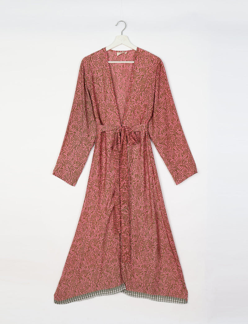 Pink tropical patterned beach robe with long sleeves, V-neck, waist tie, and contrasting dotted hem, hanging on white hanger