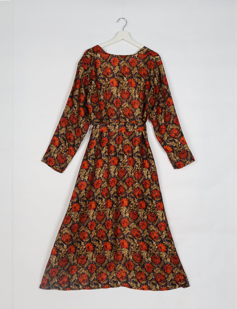 Brown beach robe with red floral pattern, long sleeves, and belt, shown hanging on white hanger against white background